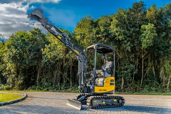 Mini escavadeira DIEL DE18MP com o braço de escavação elevado, em área externa