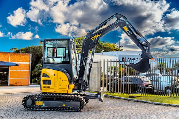 Mini escavadeira DIEL DE35MP em vista lateral traseira, com braço estendido
