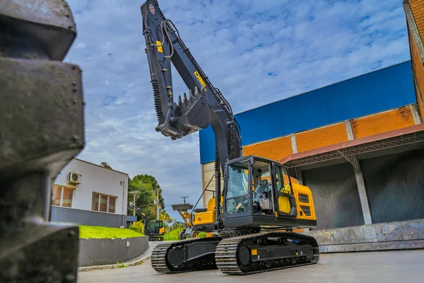DIEL DE220.8LC em vista lateral de três quartos com a caçamba elevada